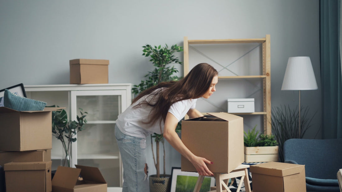 Woman unpacking cardboard boxes in a new apartment