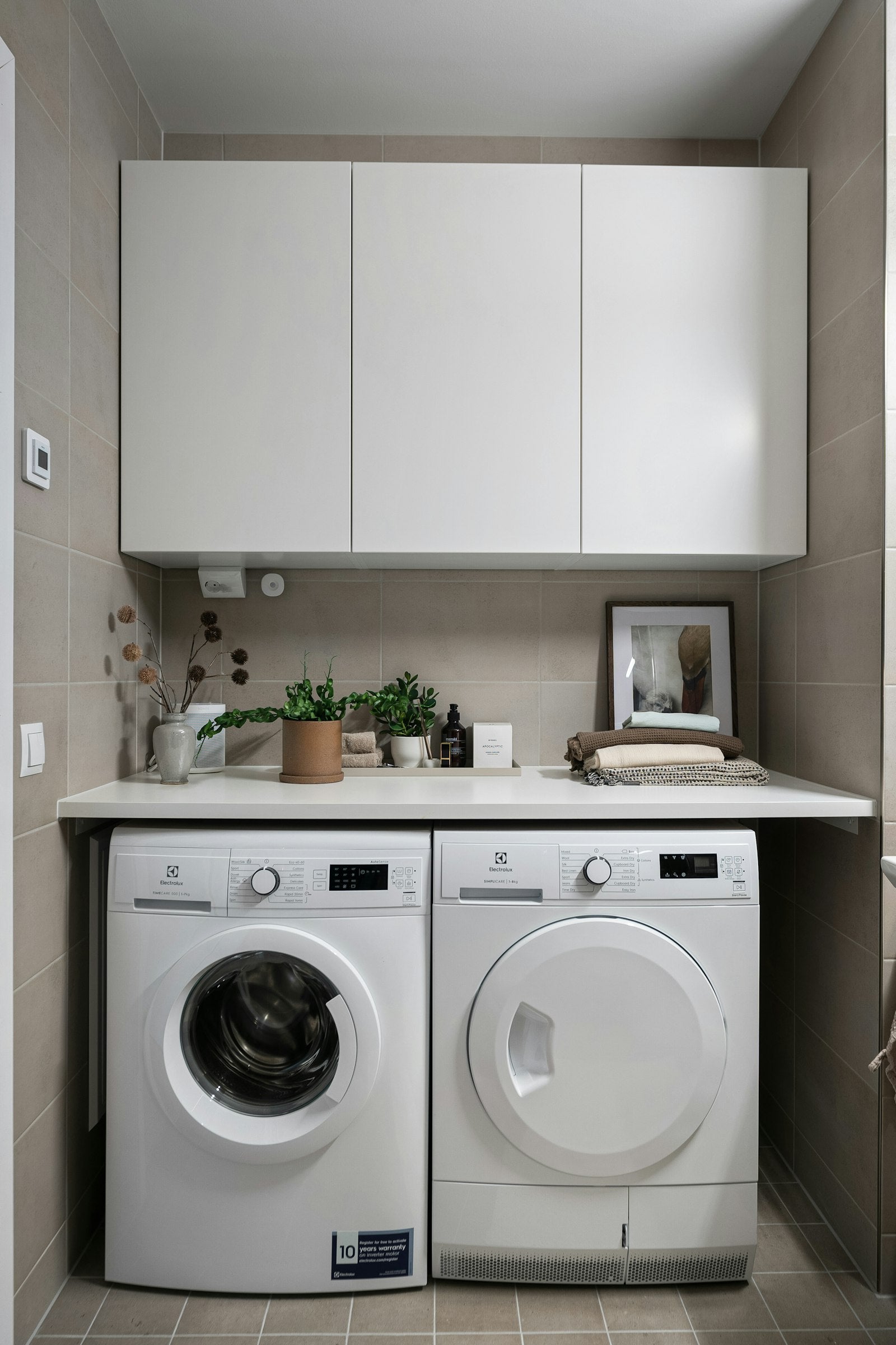 Compact neutral laundry room with a washer and dryer